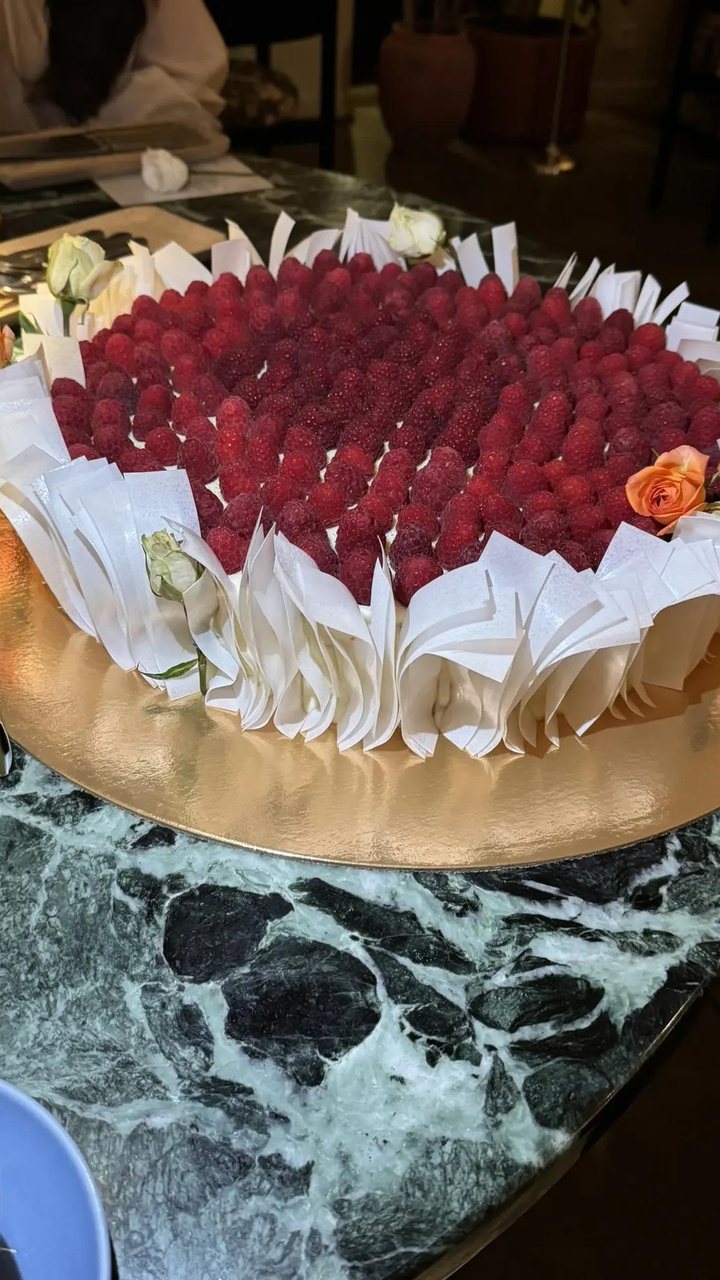Свадебный торт с малиной, белыми лепестками и розами крупным планом